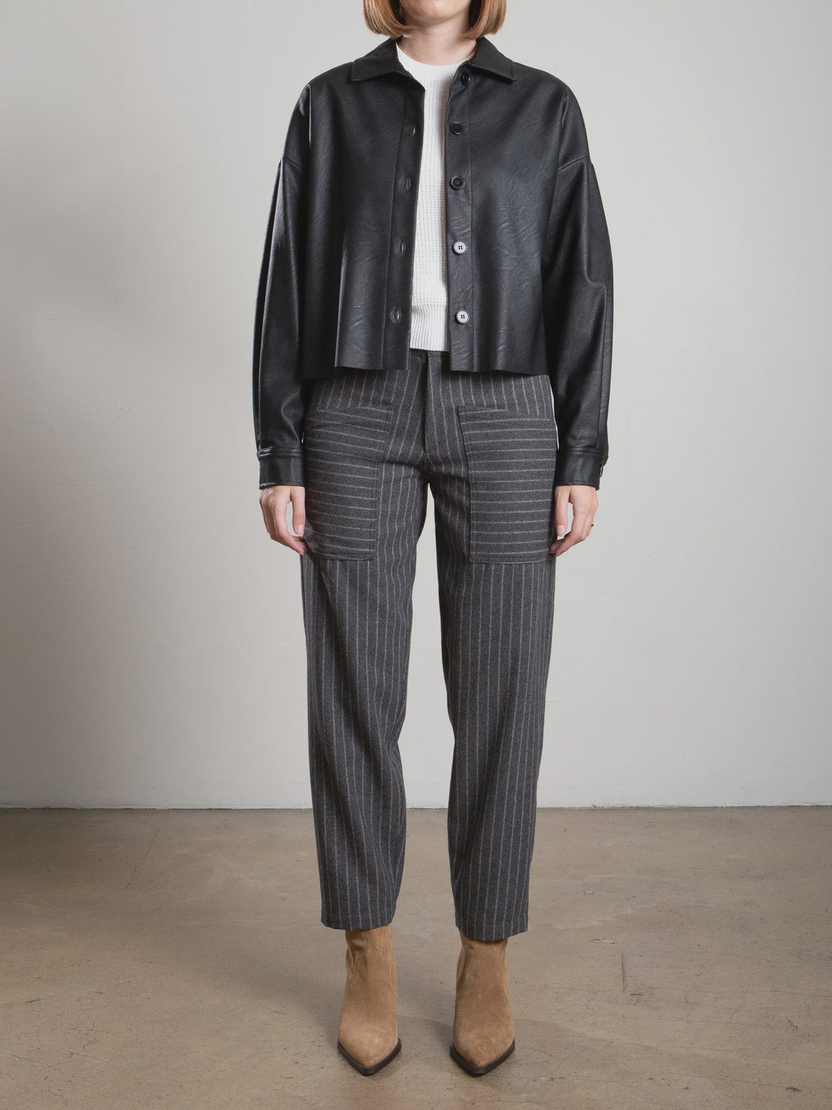 Ezra Pant in Wool Pinstripe, grey pinstriped trousers with patch pockets, styled with a white top and black jacket.