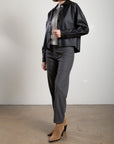 Pharaoh Ezra Pant in gray wool pinstripe worn with a white sweater and black jacket.