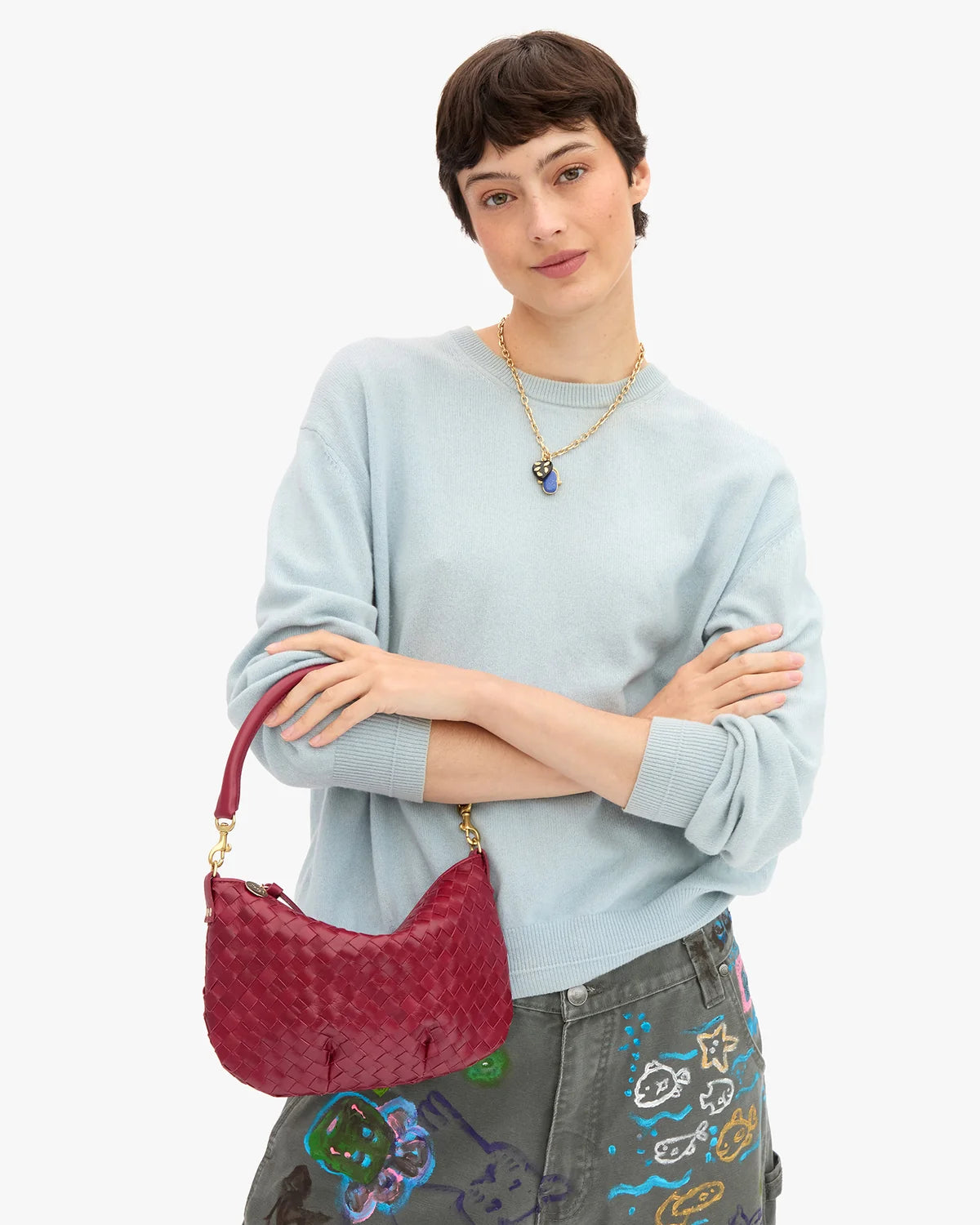 Clare Vivier Petit Moyen Messenger 26, red leather crossbody, styled with blue sweater and gray doodle pants.