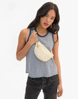 Clare Vivier Petite Fanny S26 white crossbody bag styled with a striped tank and black jeans for a casual look.