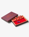 Printworks Shut The Box classic wooden game with red tiles and blue dice beside its purple box lid.