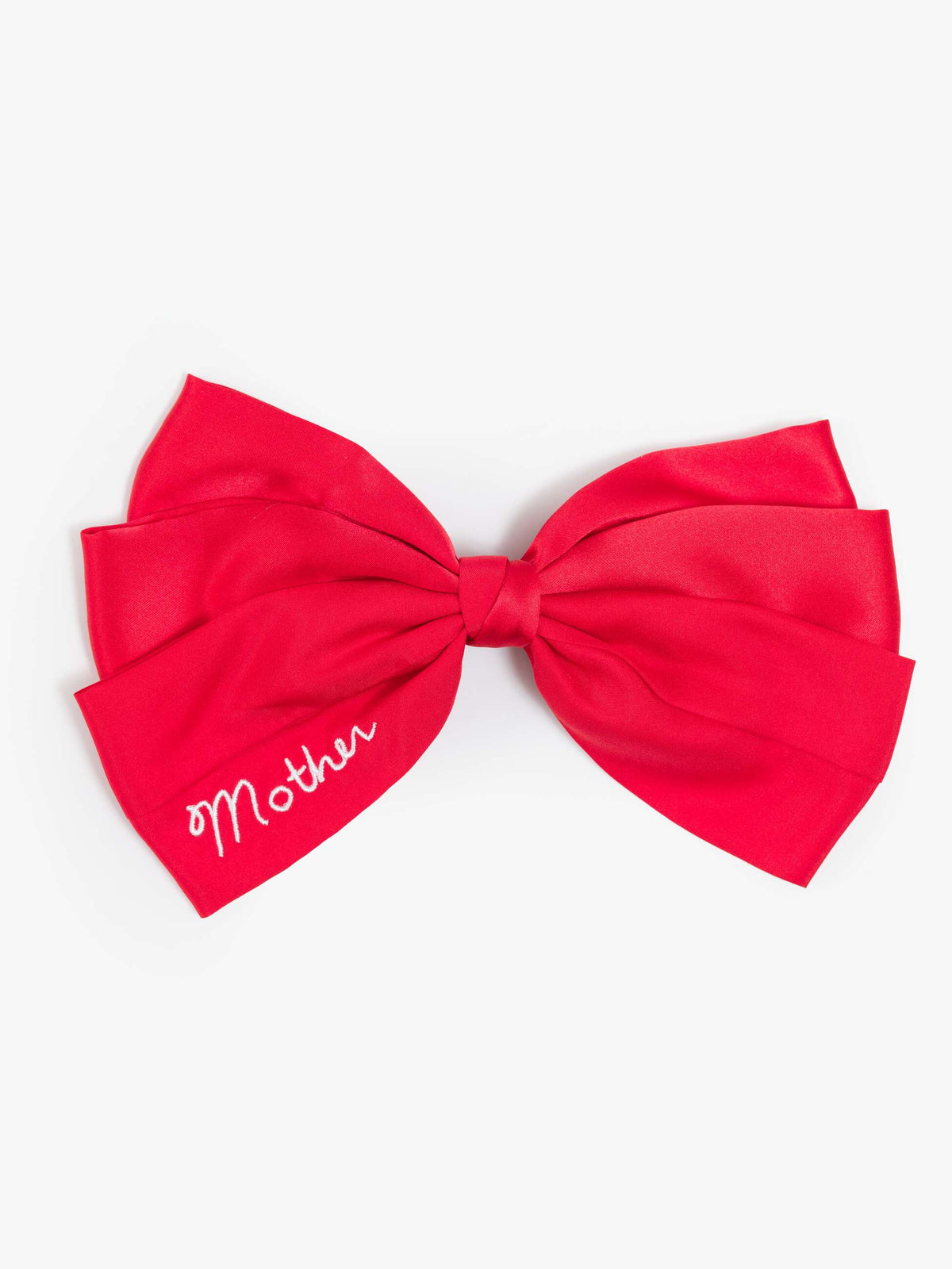 Red silk hair bow by THE BOW with white embroidered script detail on one tail.