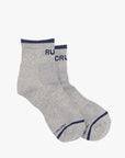 Baby Steps Ankle socks by Mother, in light gray with dark blue trim and blue "MOTHER" text on the cuffs and toes, shown on a plain white background.