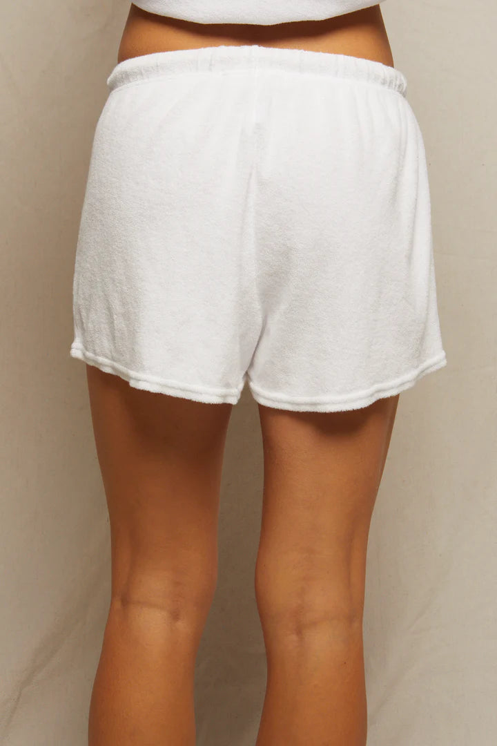 A person is shown from the waist down wearing Perfectwhitetee's Summer Loop Terry Sweat Shorts with an elastic waistband and a short length, offering luxurious loungewear comfort against a neutral background.