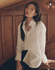 Oversized white The Ruffle Neck Shirt with a tied scarf from Bungalow Furniture & Accessories.