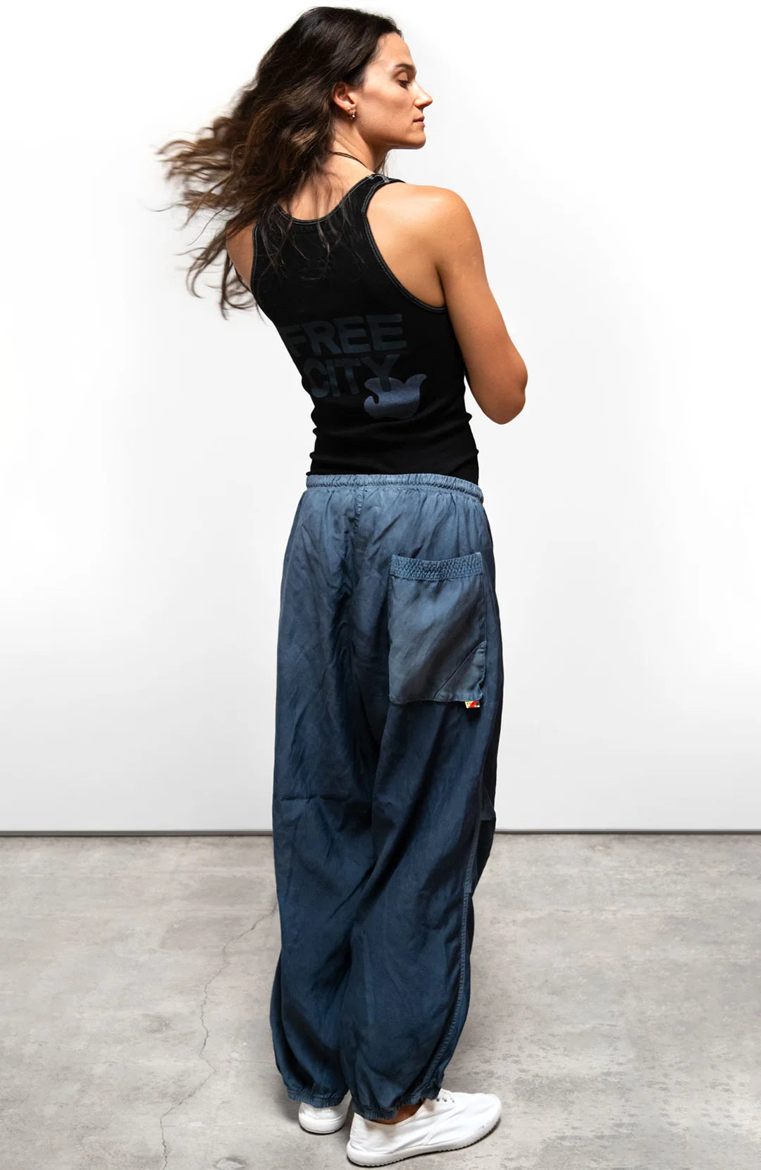 Free City Matte Satin Loose Drawcord Biggy Pant in Moonshrooms styled with a black tank top and white sneakers.