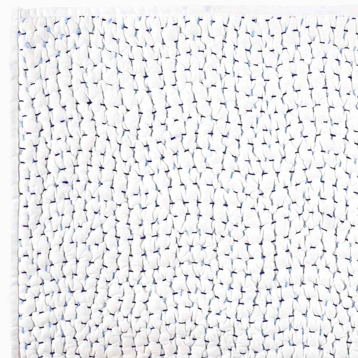 Close-up of the John Robshaw Hand Stitched Coverlet King, featuring white textured fabric with gathered sections and blue stitches for a unique, hand-stitched quilted look.