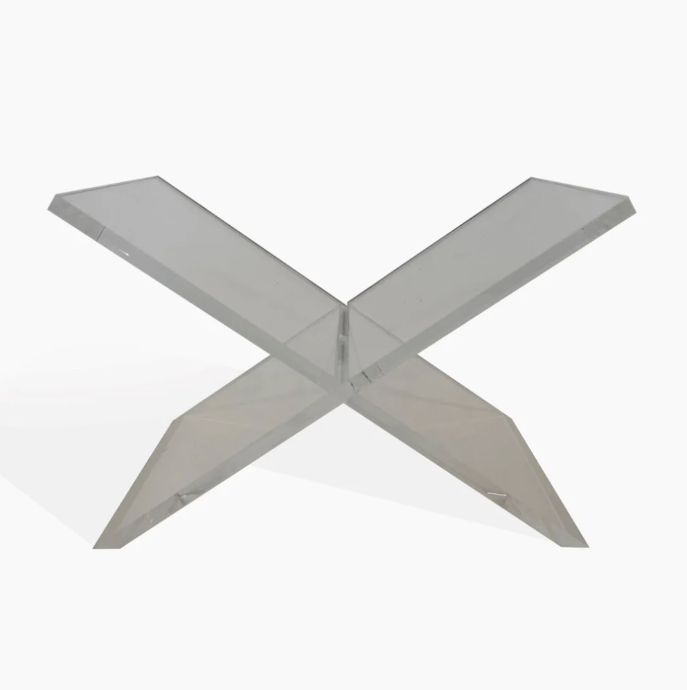 A clear acrylic book stand in an X-shape design, isolated on a white background, showcasing a sleek and minimalist style perfect for a Scottsdale Arizona bungalow by Anne Neilson Home.