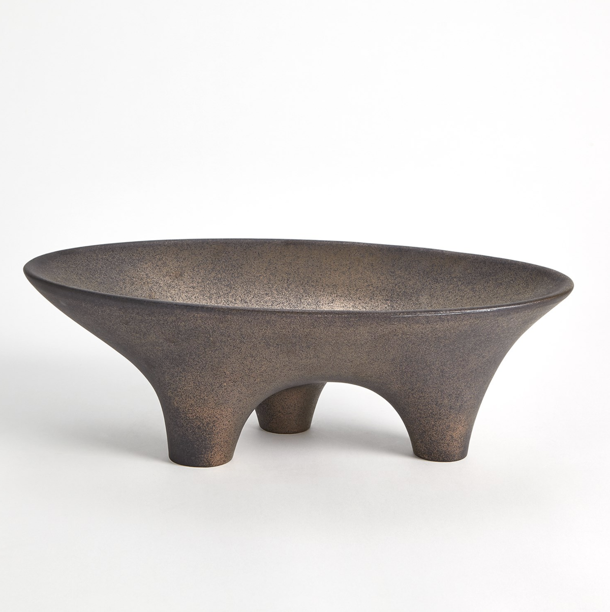 A wide, shallow clay bowl with a matte, speckled finish and three rounded legs—the Opus Triple Leg Bowl by Global Views stands out against a plain white background.