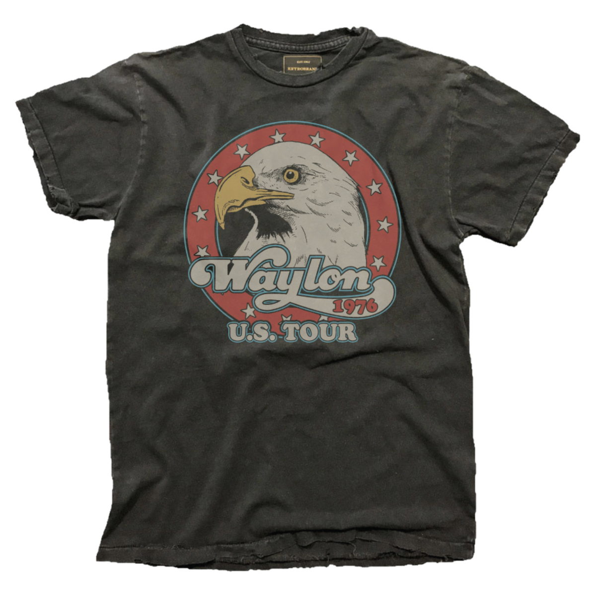 The Wildcat Retro Brands "Waylon Jennings U.S. Tour '76" tee is a vintage-style faded black shirt featuring a bald eagle head in a red star circle and retro "Waylon 1976 U.S. Tour" text on the front.