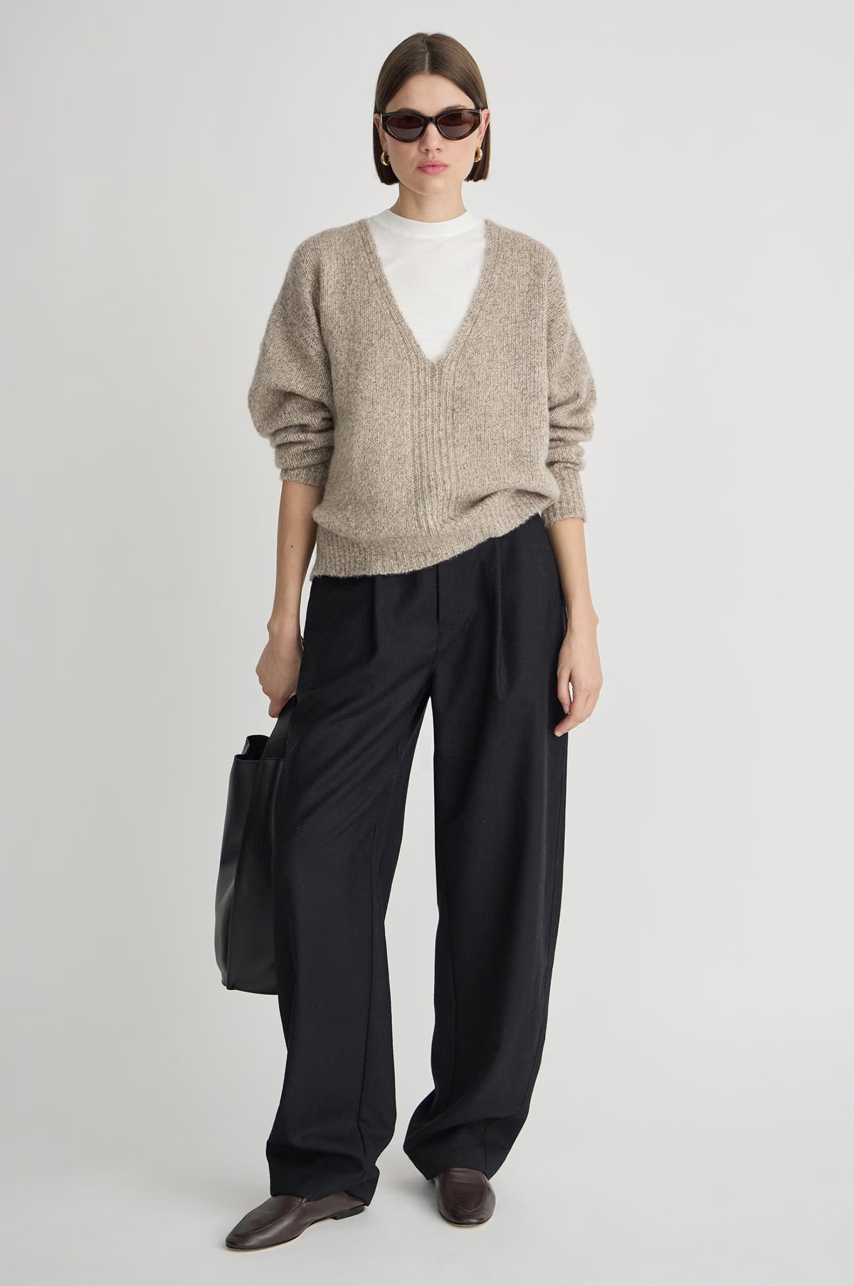 Apiece Apart Softest Silk Cashmere V-Neck Marl sweater styled with wide black pants and a black handbag.