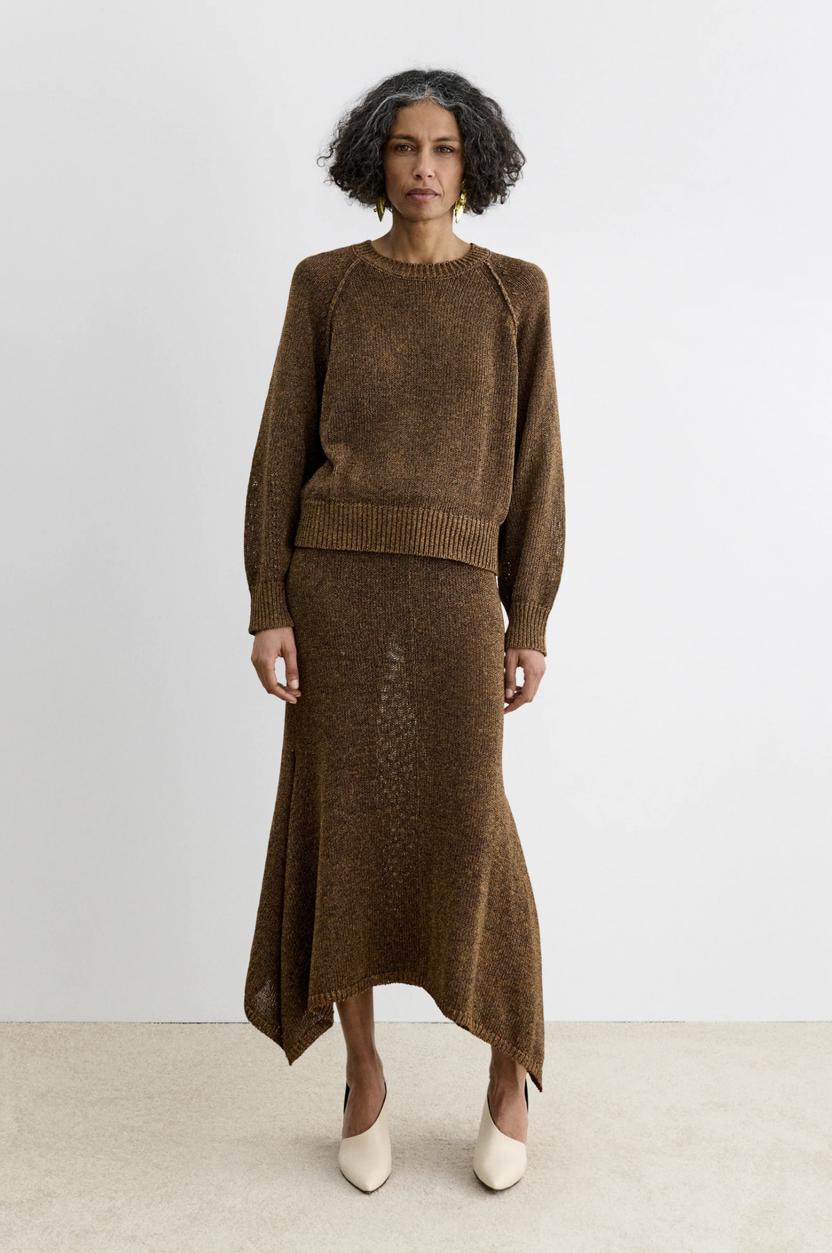 Rachel Comey Lenco Skirt with brown knit sweater and cream heels, metallic yarns, against a white background.