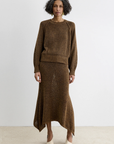 Rachel Comey Lenco Skirt with brown knit sweater and cream heels, metallic yarns, against a white background.