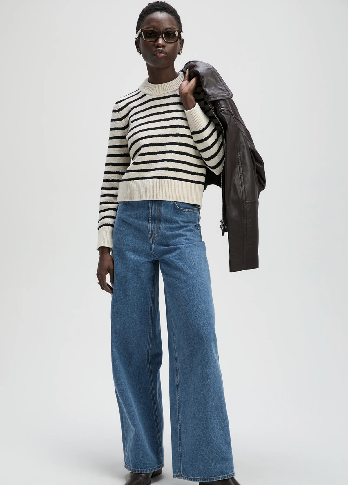 The Favorite Crew by Sold Out NYC styled with wide-leg jeans and sunglasses against a plain backdrop.