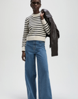 The Favorite Crew by Sold Out NYC styled with wide-leg jeans and sunglasses against a plain backdrop.