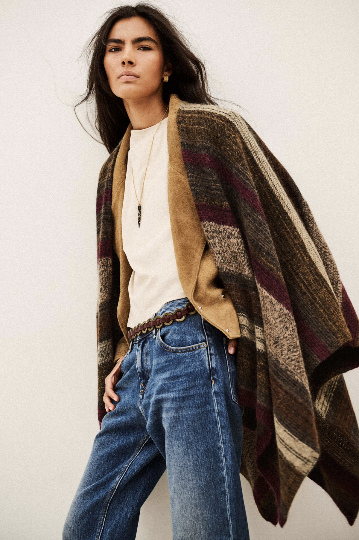 BA&SH Poncho Perros in a light setting, styled with white top and blue jeans for a casual, modern look.