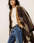 BA&SH Poncho Perros in a light setting, styled with white top and blue jeans for a casual, modern look.