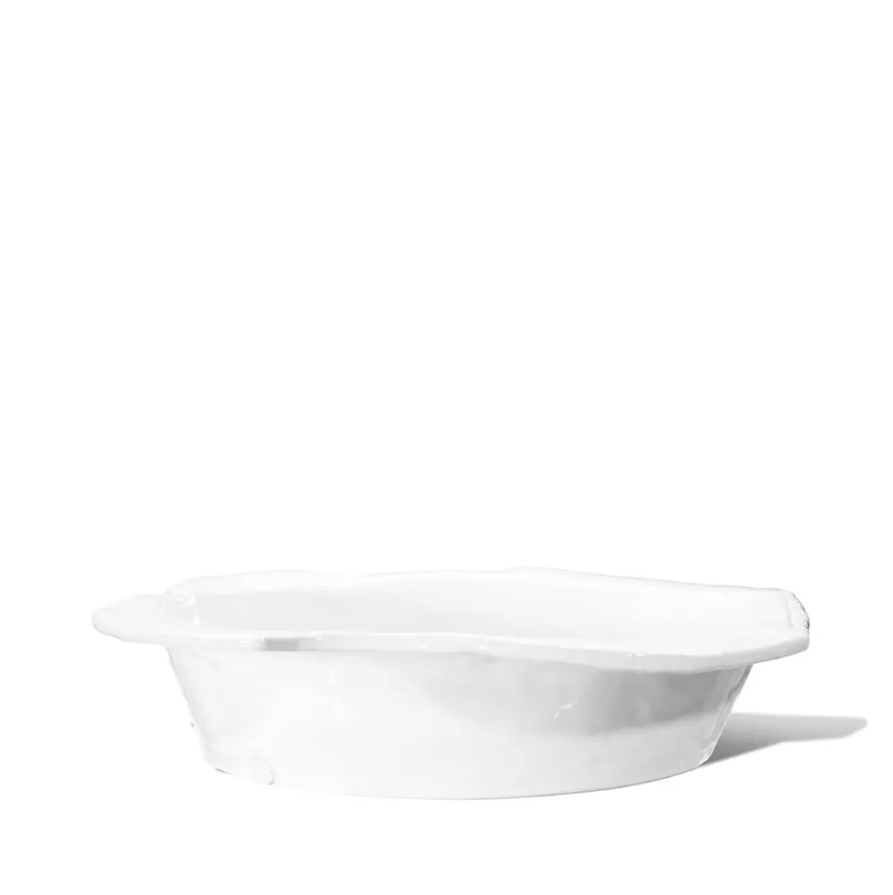 The Montes Doggett 5442-L Bowl No.442L is a handmade, high-fired white ceramic dish with a subtly scalloped edge, crafted in Peru and displayed against a plain white background.