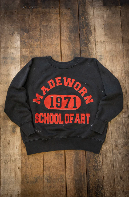 The Made Worn Madeworn Shrunken Sweatshirt is a black heavyweight cotton piece with bold red "MADEWORN 1971 SCHOOL OF ART" text, handmade in Los Angeles for a classic vintage look.