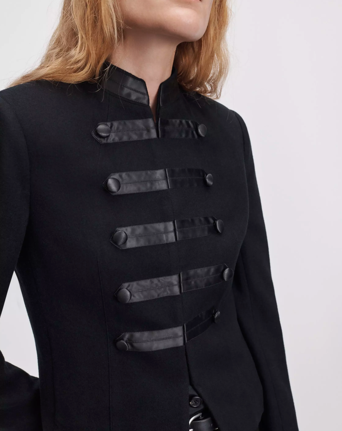 Black blazer with faux leather straps and buttons by Rag & Bone, Mercer Regalia style, shown shoulders up.