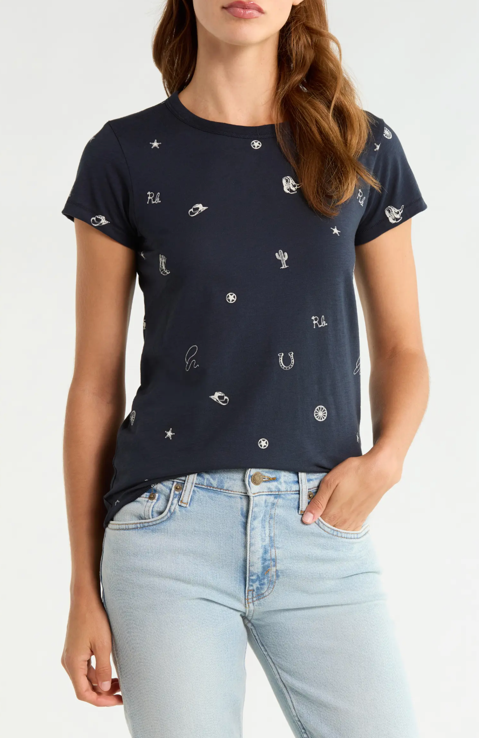 Rag & Bone rodeo graphic tee in white paired with light blue jeans, casual hand-in-pocket look.