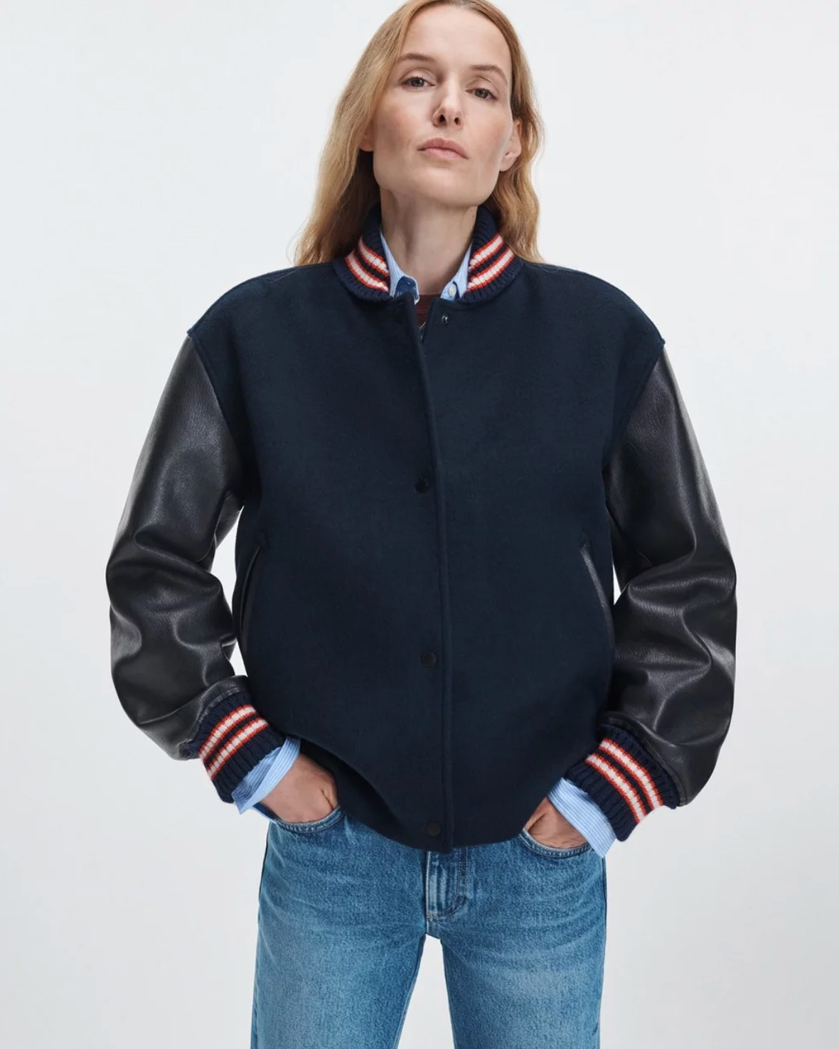 Rag & Bone Scarlet Varsity jacket with faux leather sleeves styled with blue jeans, hands in pockets.