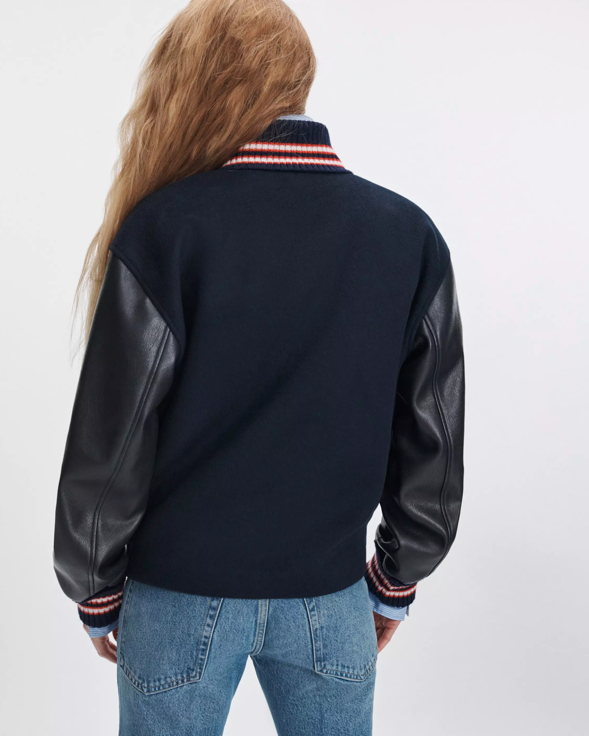 Scarlet varsity jacket with faux leather sleeves by Rag & Bone, shown from the back with blue jeans.