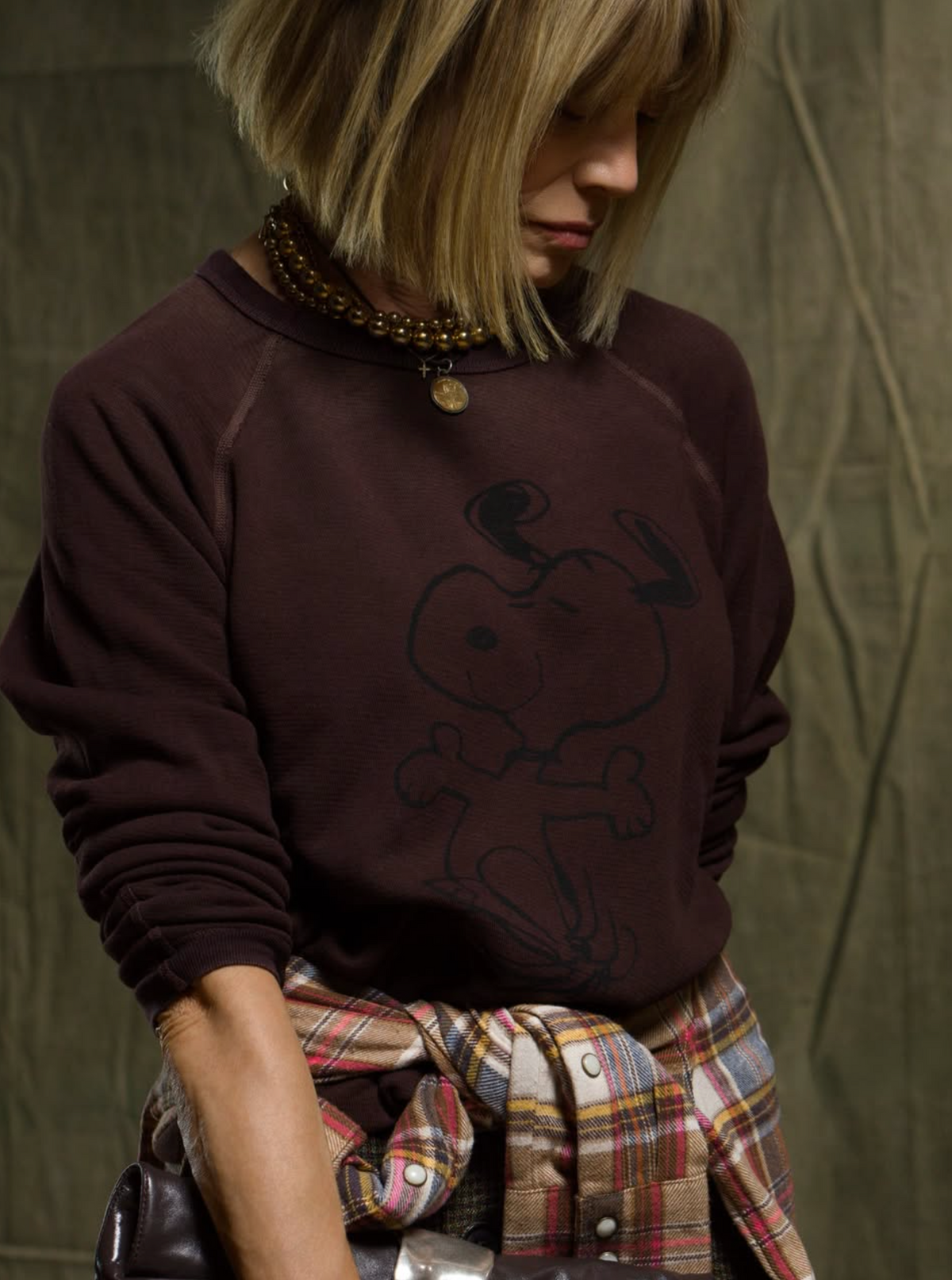 Oversized Free City Schulz Raglan sweatshirt in Snoopy Chocolate, plaid shirt at waist, casual style.