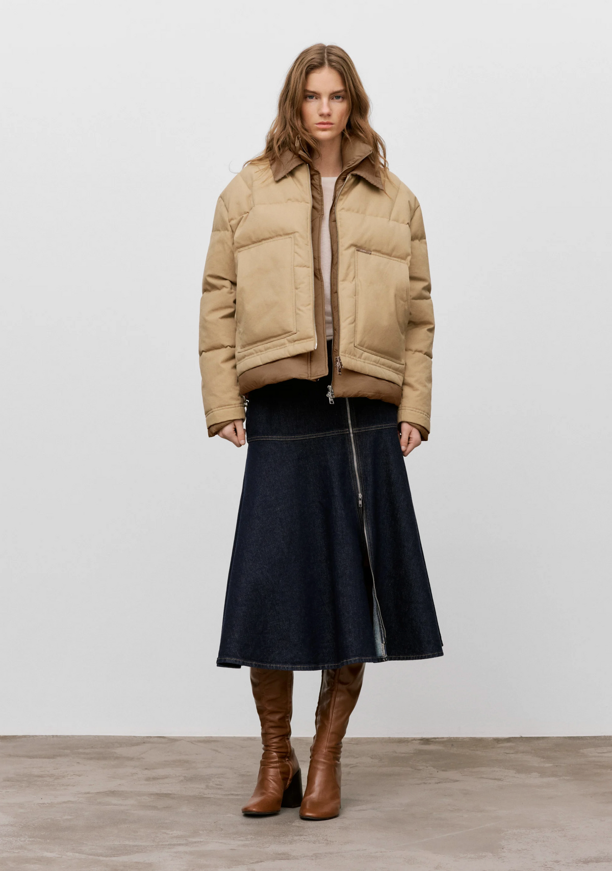 CLOSED Midi Zip Skirt worn with a tan puffer jacket and brown knee-high boots.