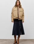 CLOSED Midi Zip Skirt worn with a tan puffer jacket and brown knee-high boots.