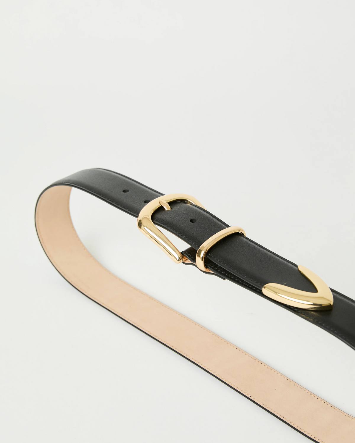 The Marc Belt by B-Low The Belt features black calfskin leather, gold-tone hardware with a matching gold loop, and a tan inner side, shown coiled on a white background.