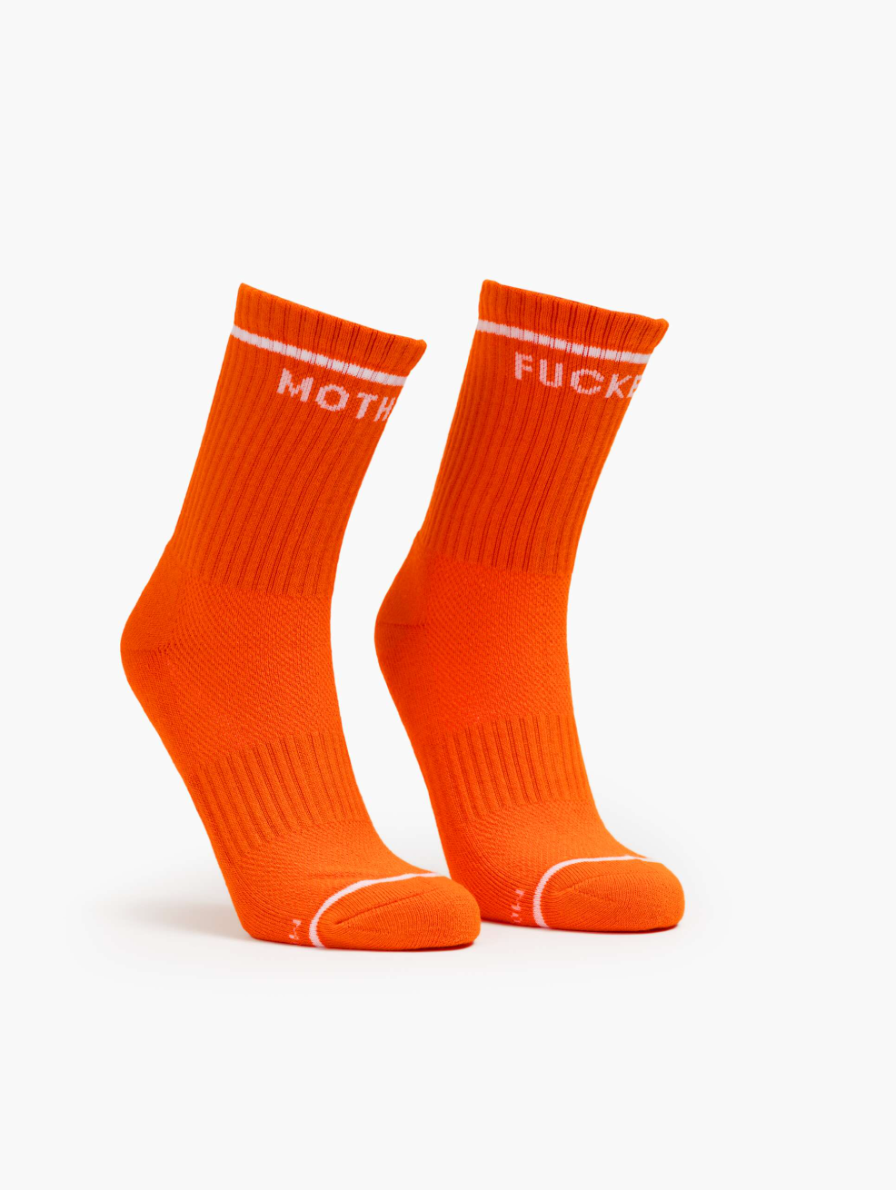 A pair of bright orange "Baby Steps" socks by Mother, with white ribbed cuffs and bold "MOTH" on the left and "FUCK" on the right sock in capital letters near the top.