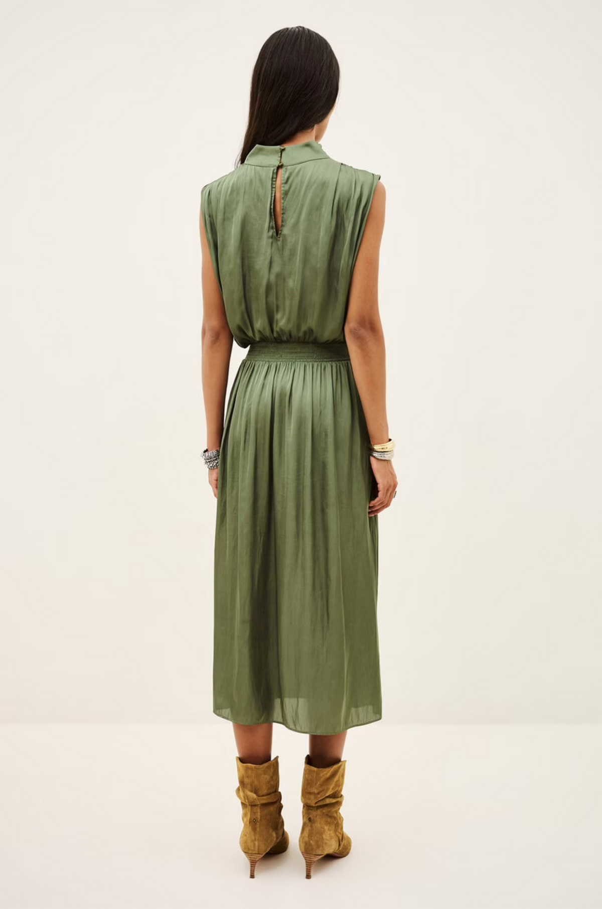 Sleeveless green BA&SH Celea midi dress with draped collar, styled with brown boots at Bungalow Furniture.