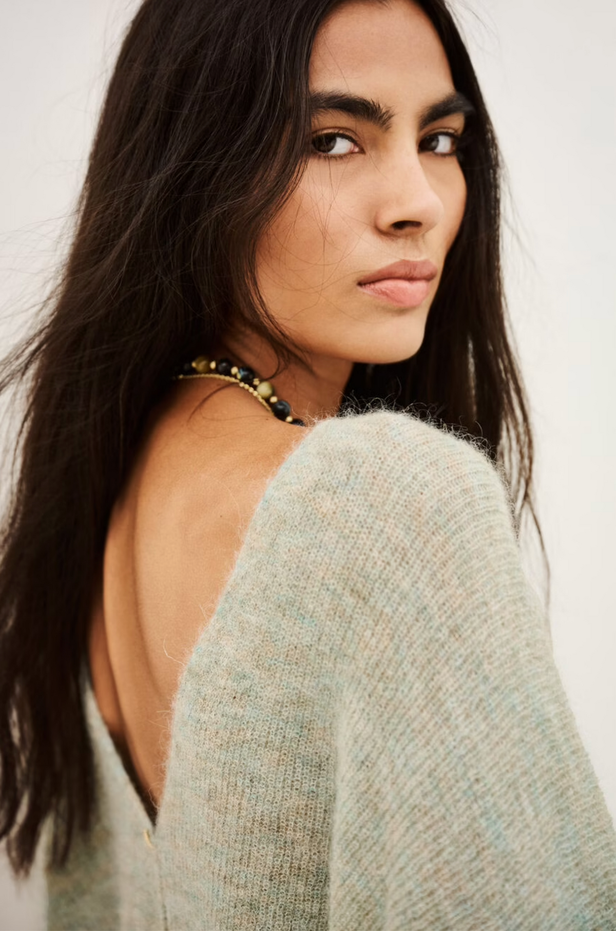 BA&SH Cardigan Isaac in dark fabric, modeled by woman looking over her shoulder; modern, elegant style.