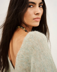 BA&SH Cardigan Isaac in dark fabric, modeled by woman looking over her shoulder; modern, elegant style.