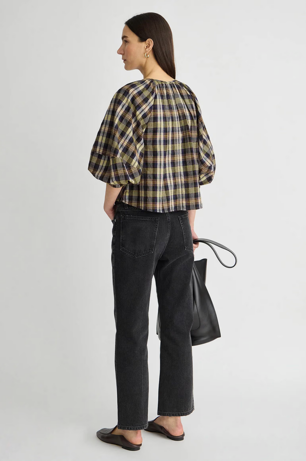 Apiece Apart Nele Lantern Sleeve Top in white, styled with black jeans and flats, model facing away.