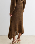 Rachel Comey Lenco Skirt styled with sweater and beige heels on a light carpet in a bright, modern room.