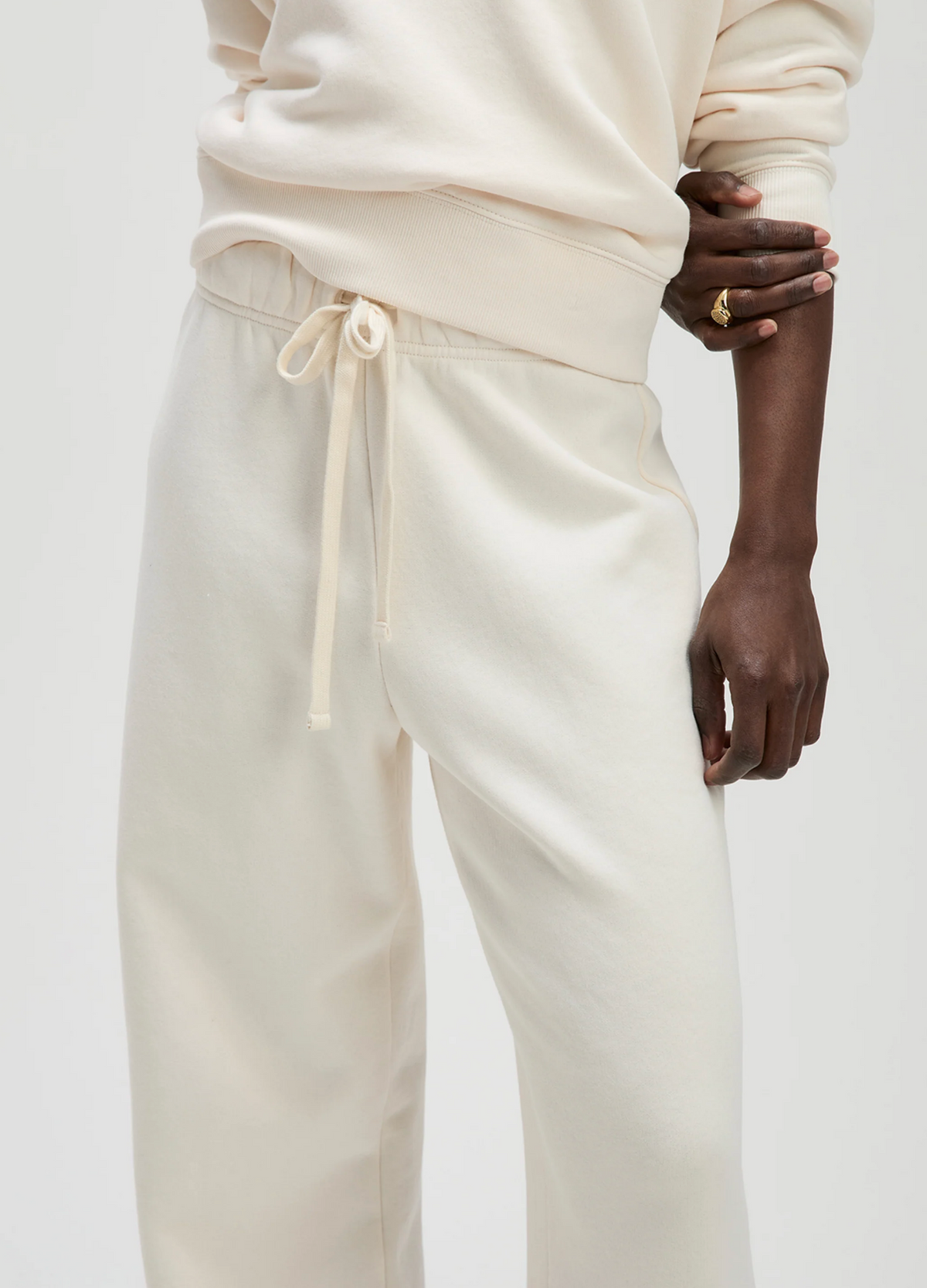 Cream French terry sweatpants by Sold Out NYC styled with a matching sweatshirt and gold ring.