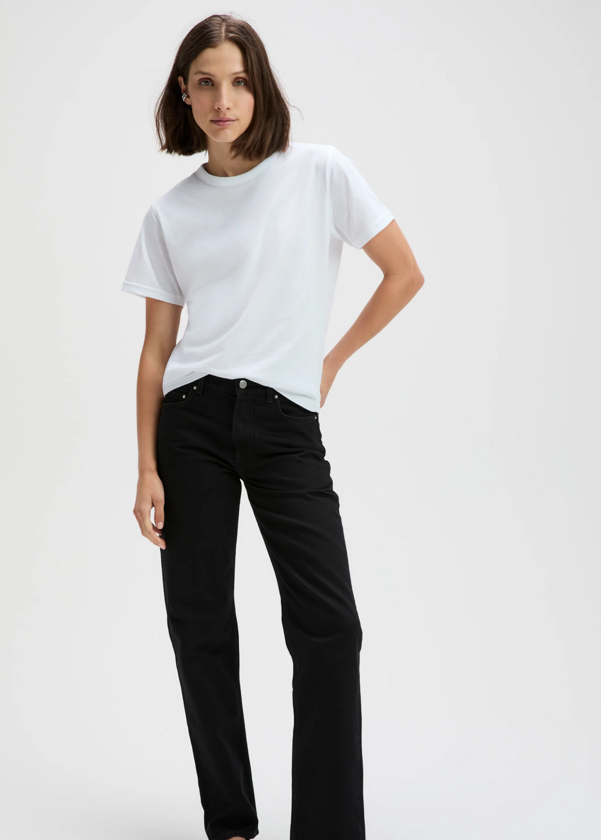 The Iconically Soft Perfect Tee in white styled with black jeans by Sold Out NYC, minimal backdrop.