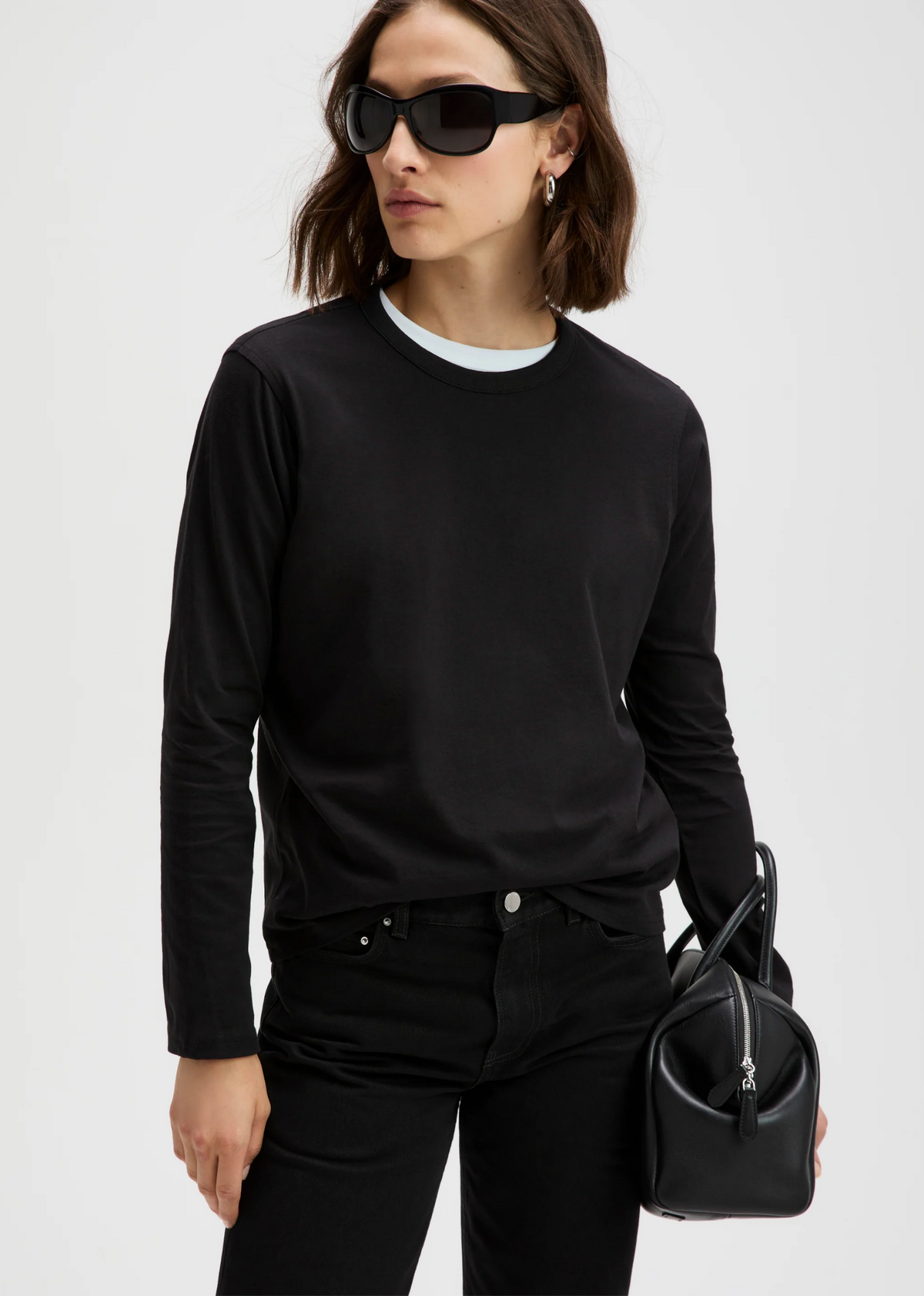 Sold Out NYC Long Sleeve Perfect Tee and pants styled with black sunglasses and a small black bag, modern city look.