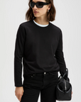 Sold Out NYC Long Sleeve Perfect Tee and pants styled with black sunglasses and a small black bag, modern city look.