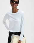 Long sleeve Perfect Tee by Sold Out NYC styled with sunglasses, cream bag, and black sweater at the waist.