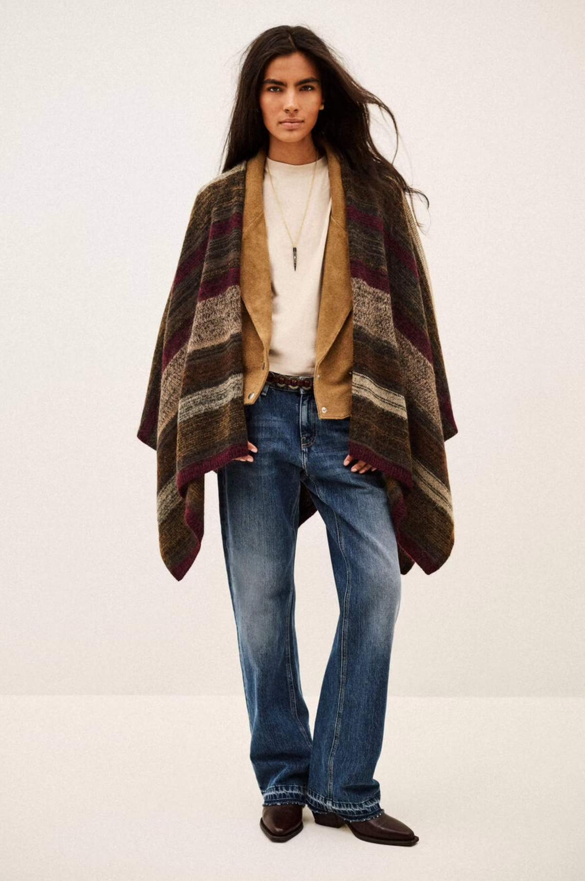 BA&SH Poncho Perros styled over casual jeans and jacket, modern neutral look against a plain backdrop.