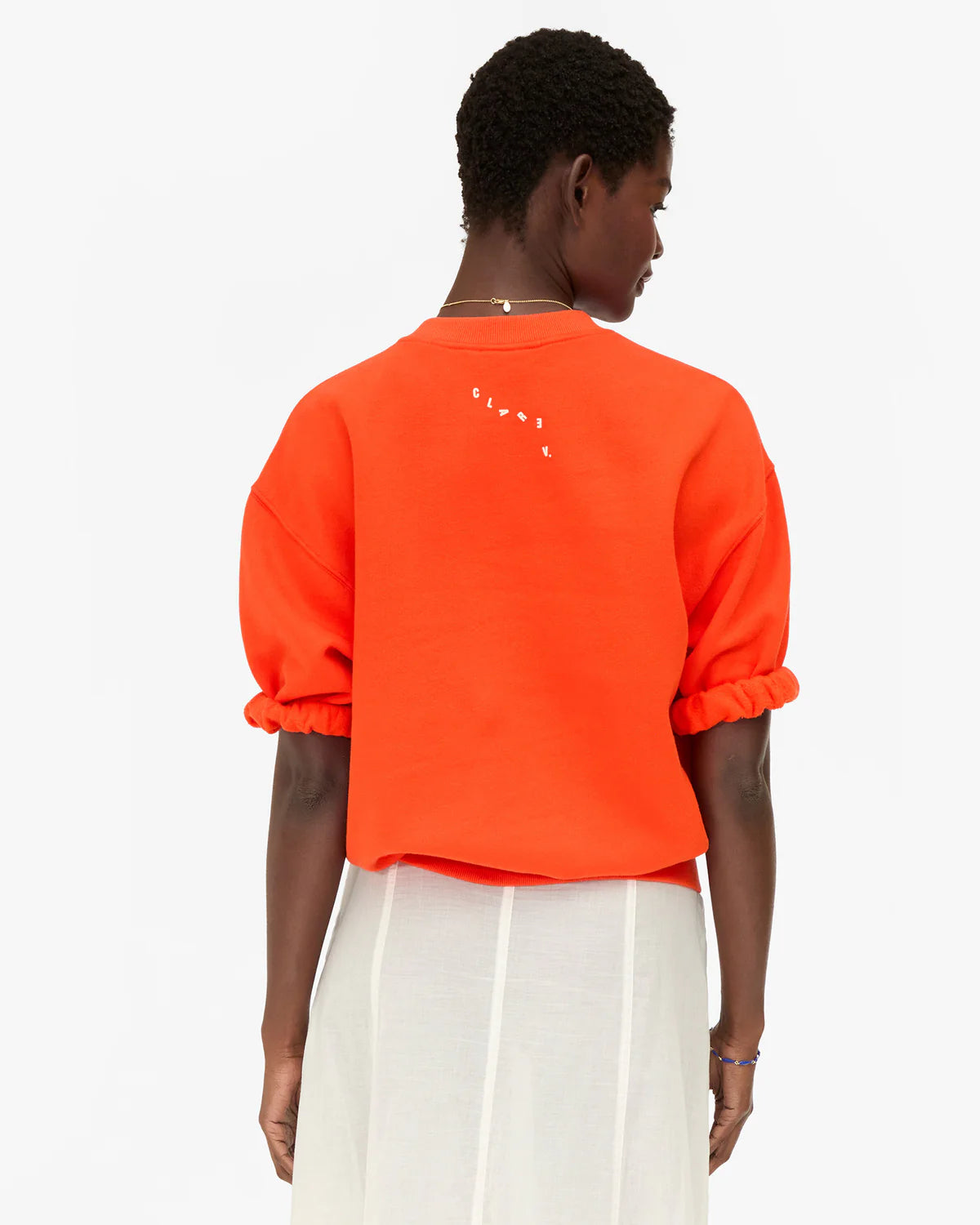 Clare Vivier short sleeve oversized sweatshirt with ruffled sleeves shown from the back, casual modern style.