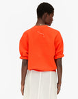 Clare Vivier short sleeve oversized sweatshirt with ruffled sleeves shown from the back, casual modern style.