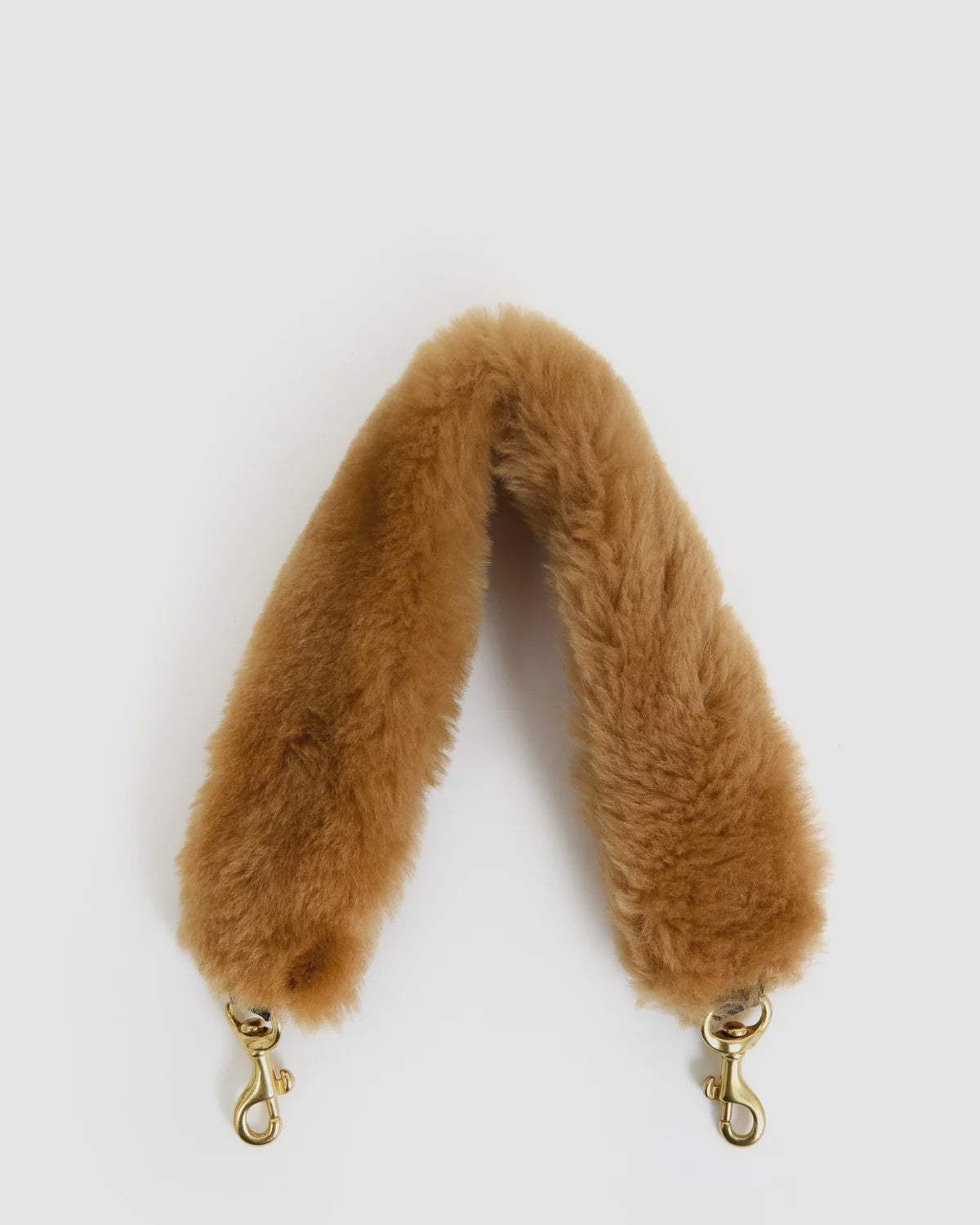 Tan shearling Shortie Strap by Clare Vivier with gold-tone swivel clasps and leather attachment.