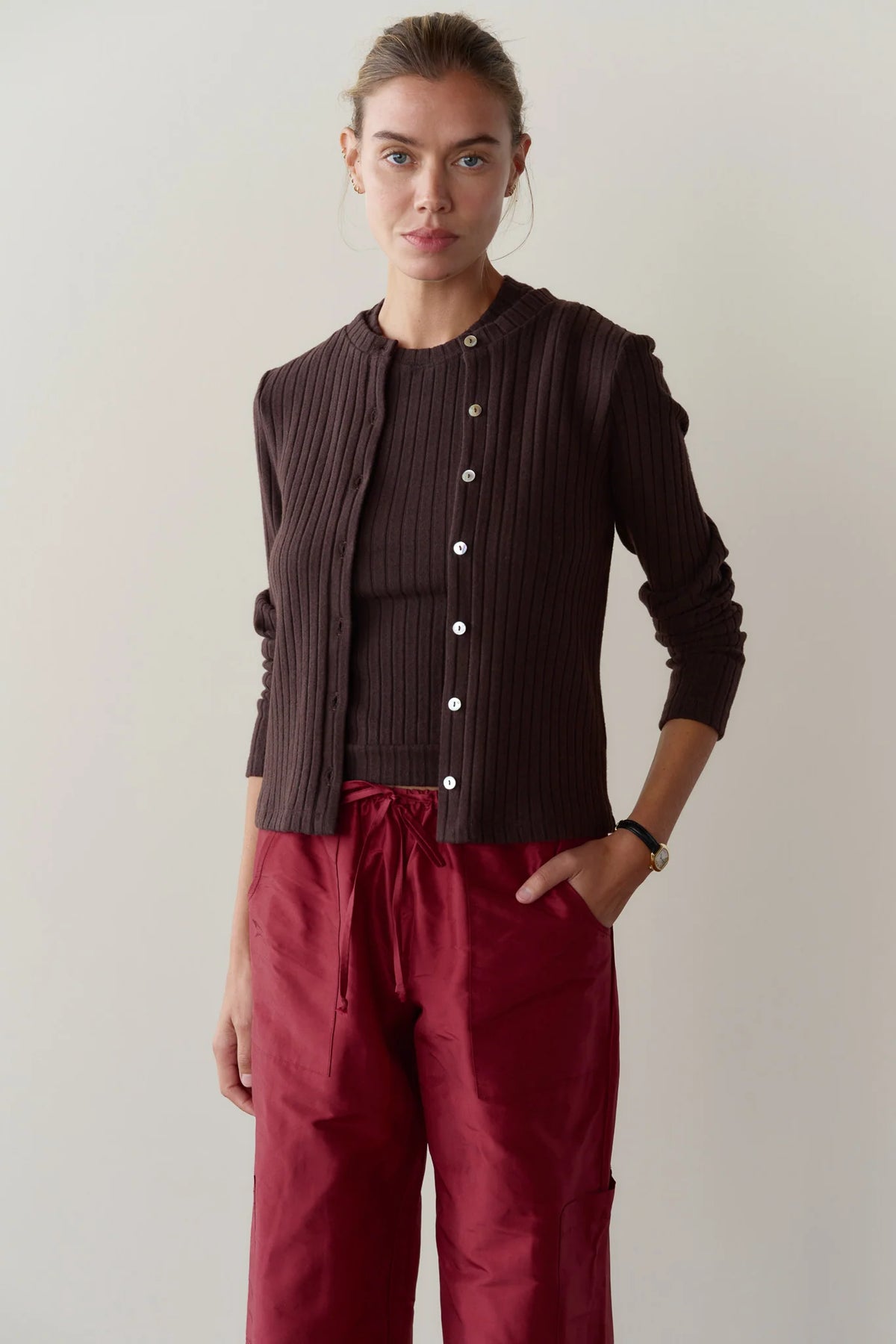 The Sweater Rib Cardi in dark brown worn with a matching sleeveless top and red drawstring pants.