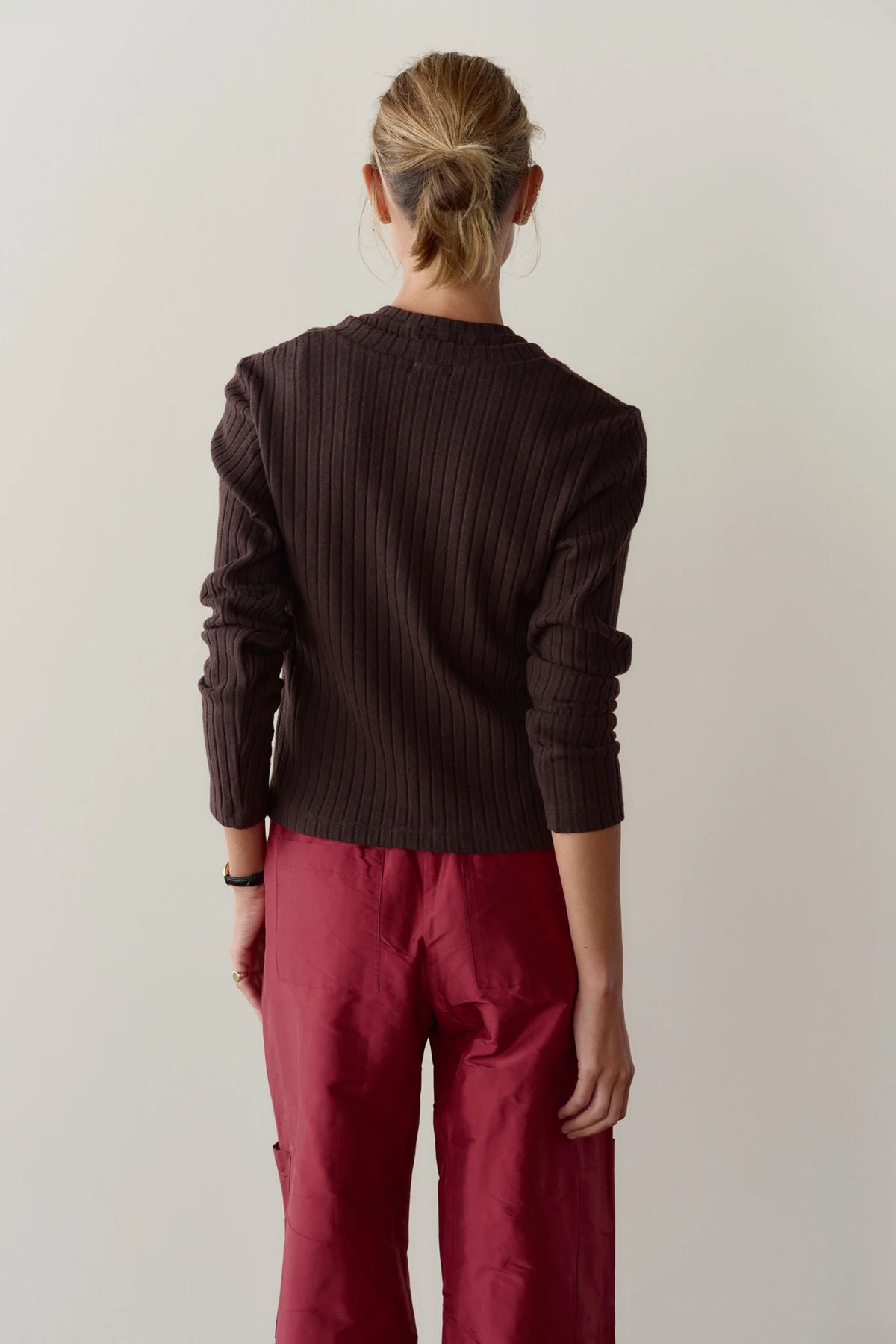 The Sweater Rib Cardi in dark brown, a close-fit long-sleeved rib knit sweater shown from the back.