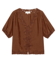 The SS Legacy Top by The Great Inc. is a brown blouse inspired by 1920s loungewear, featuring short puffed sleeves, a V-neckline, and embroidered mesh lace trim on the neckline, front, hem, and sleeves.