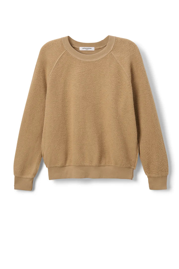 The Ziggy Reverse LS Sweatshirt by Perfectwhitetee is a tan, long-sleeve crewneck made from soft, textured cotton fleece with ribbed cuffs, hem, and neckline. Its shrunken fit is shown against a plain white background.